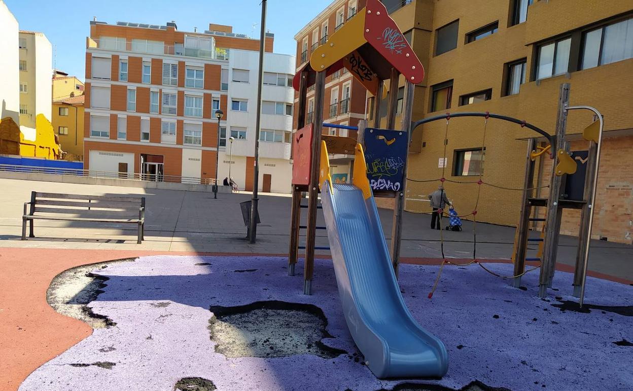 Deterioro del pavimento en la zona de columpios del parque.