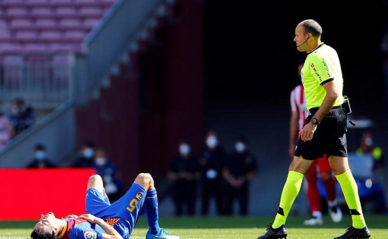 Mateu Lahoz se interesa por el estado de Sergio Busquets tras el cabezazo que sufrió ante el Atlético. 