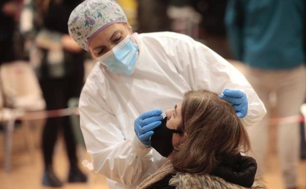 Una sanitaria realiza una prueba diagnóstico a una mujer.