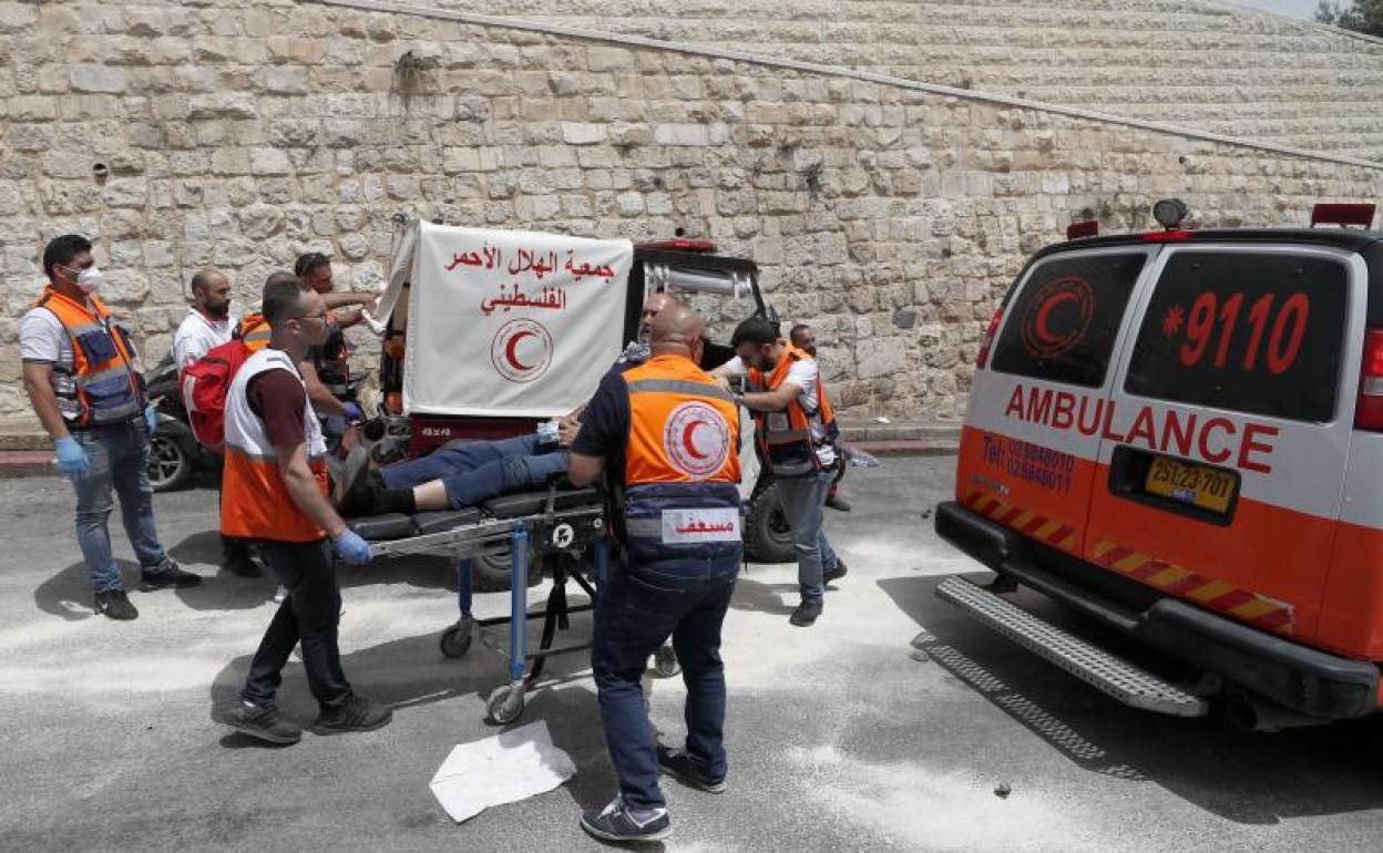 Miembros de la la Media Luna Roja trasladan a un herido. 