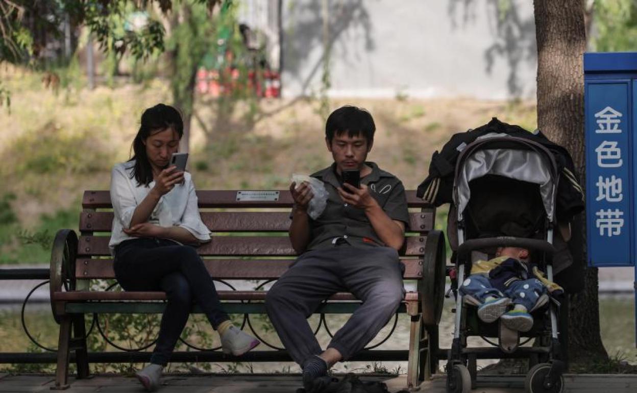 Una familia descansa en un parque de Pekín. 