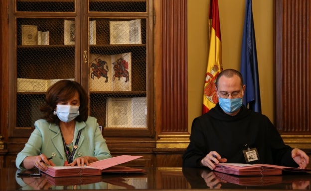 Ana Santos, directora de la BNE, y el prior Santiago Cantera en la firma del acuerdo. 