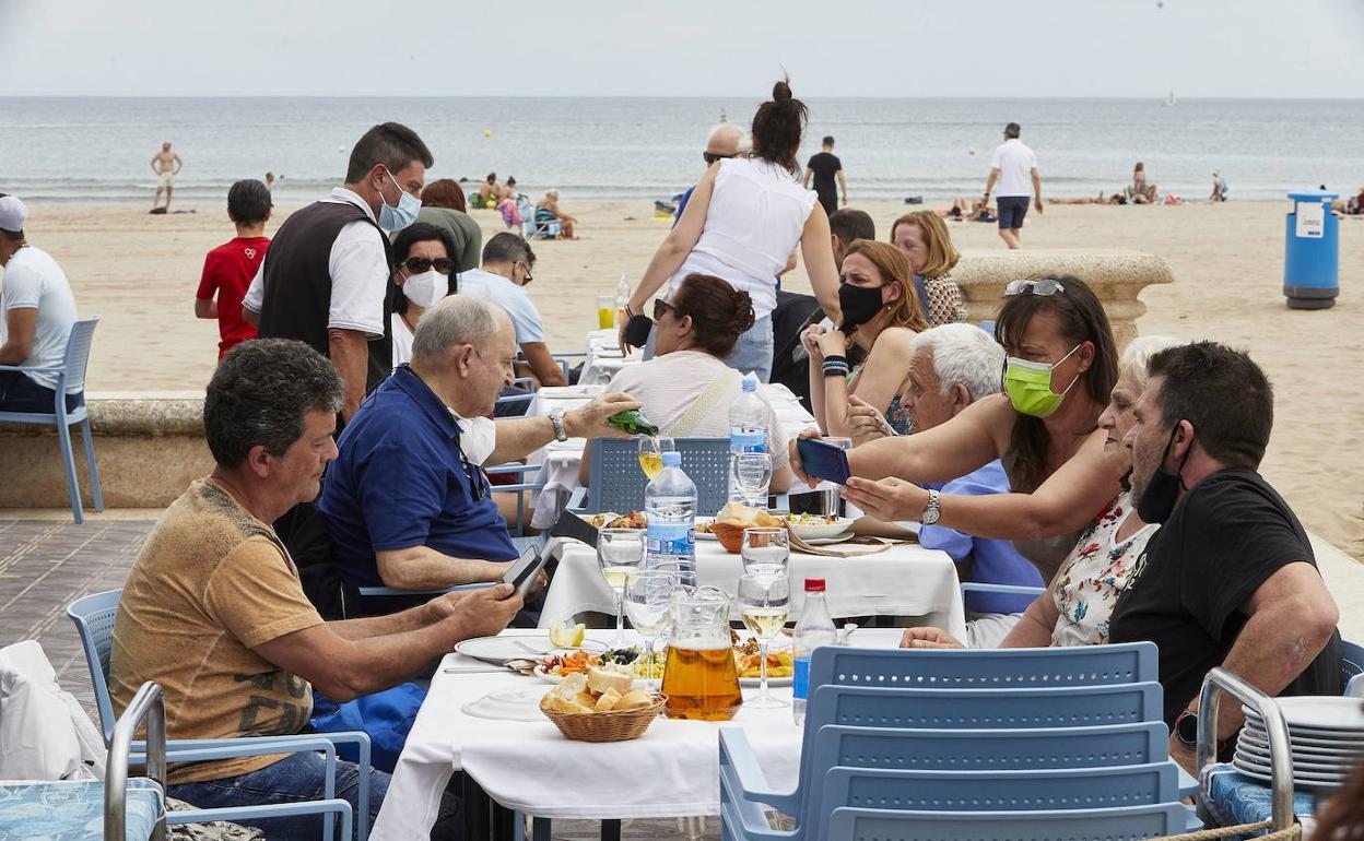 Familia en un establecimeinto de la playa de la Malvarrosa en Valencia.