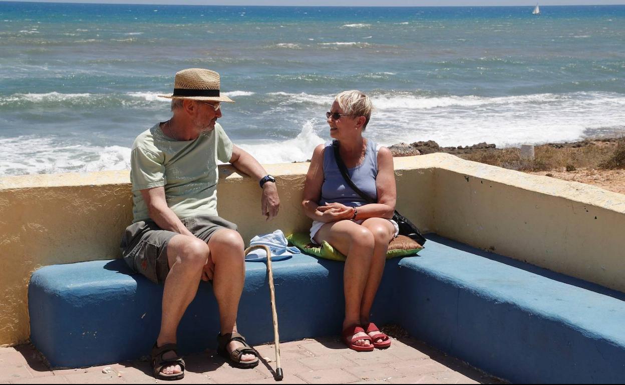 Una pareja de jubilados disfruta de la playa.