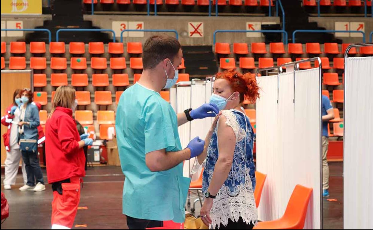 Un sanitario vacuna a una mujer en El Plantío.