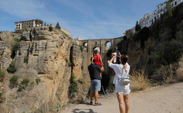 Una familia fotografía el puente de Ronda, en el interior de la provincia de Málaga.