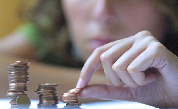 Mujer apilando monedas. 