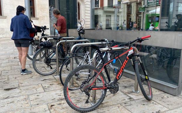 Dos personas candan sus bicicletas en el centro de Burgos.