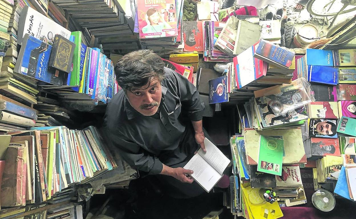 Daud Faizi, rodeado de libros, en su establecimiento del mercado literario de Kabul. 