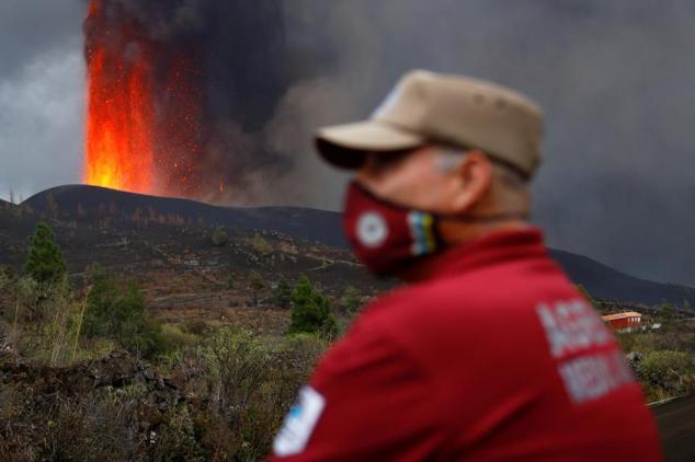 Un agente medioambiental observa cómo la lava se eleva tras la erupción del volcán.