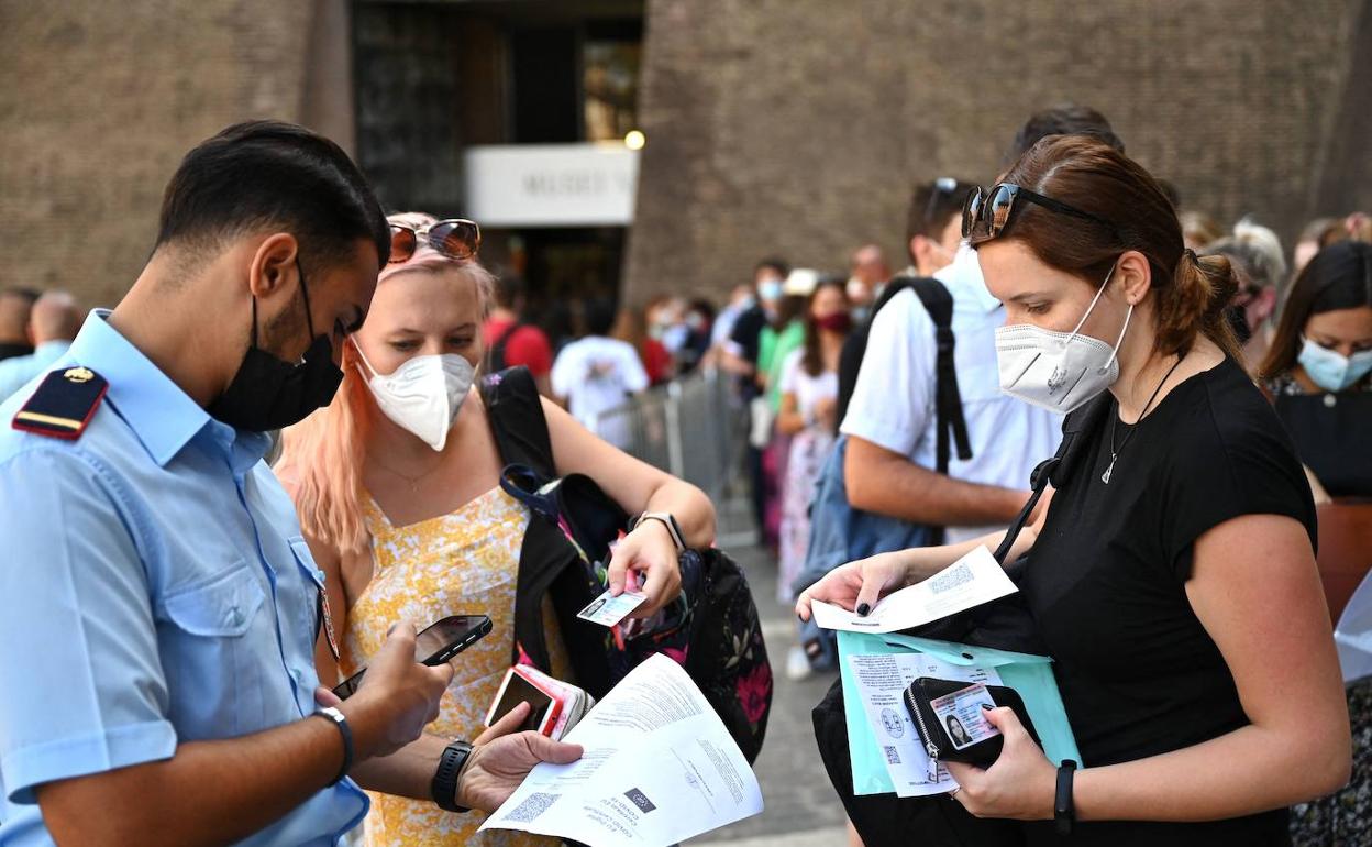 Un vigilante del Vaticano controla que las personas que acceden a las instalaciones cuenten con el pasaporte covid o certificado de vacunación.