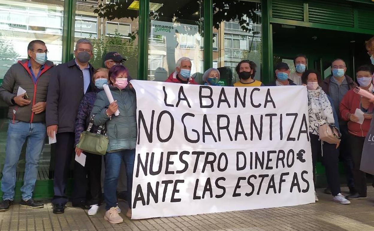 El afectado, rodeado de amigos y familiares, en la sucursal bancaria.