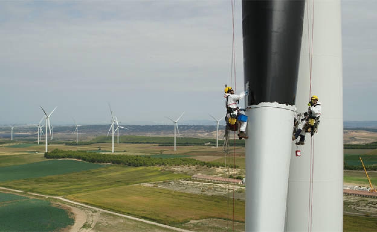 Dos operarios pintan una de las torres de Iberdrola. 