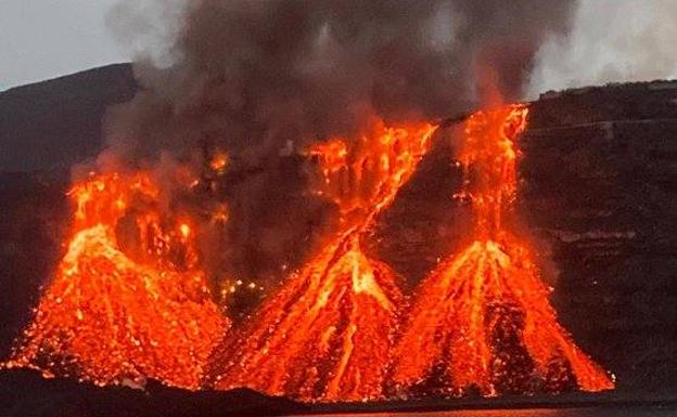 Imagen de la lava cayendo en la tarde de ayer por el acantilado de la playa de Los Guirres. 