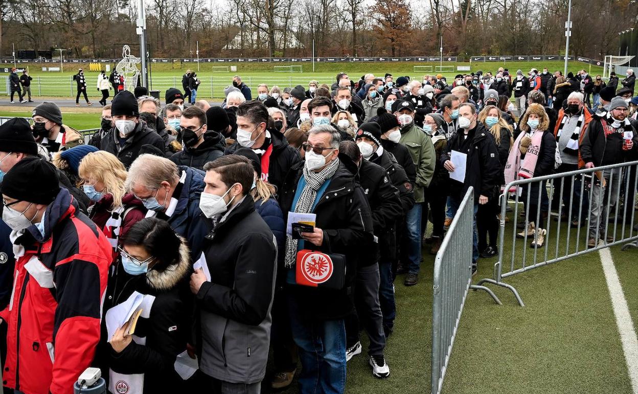 Aficionados hacen cola para vacunarse en un centro situado en el exterior de un estadio antes de un partido de la Bundesliga.