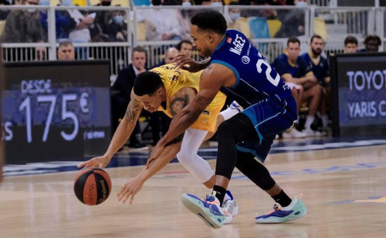 McGee trata de robar el balón al jugador de Gran Canaria, en el último partido liguero. 