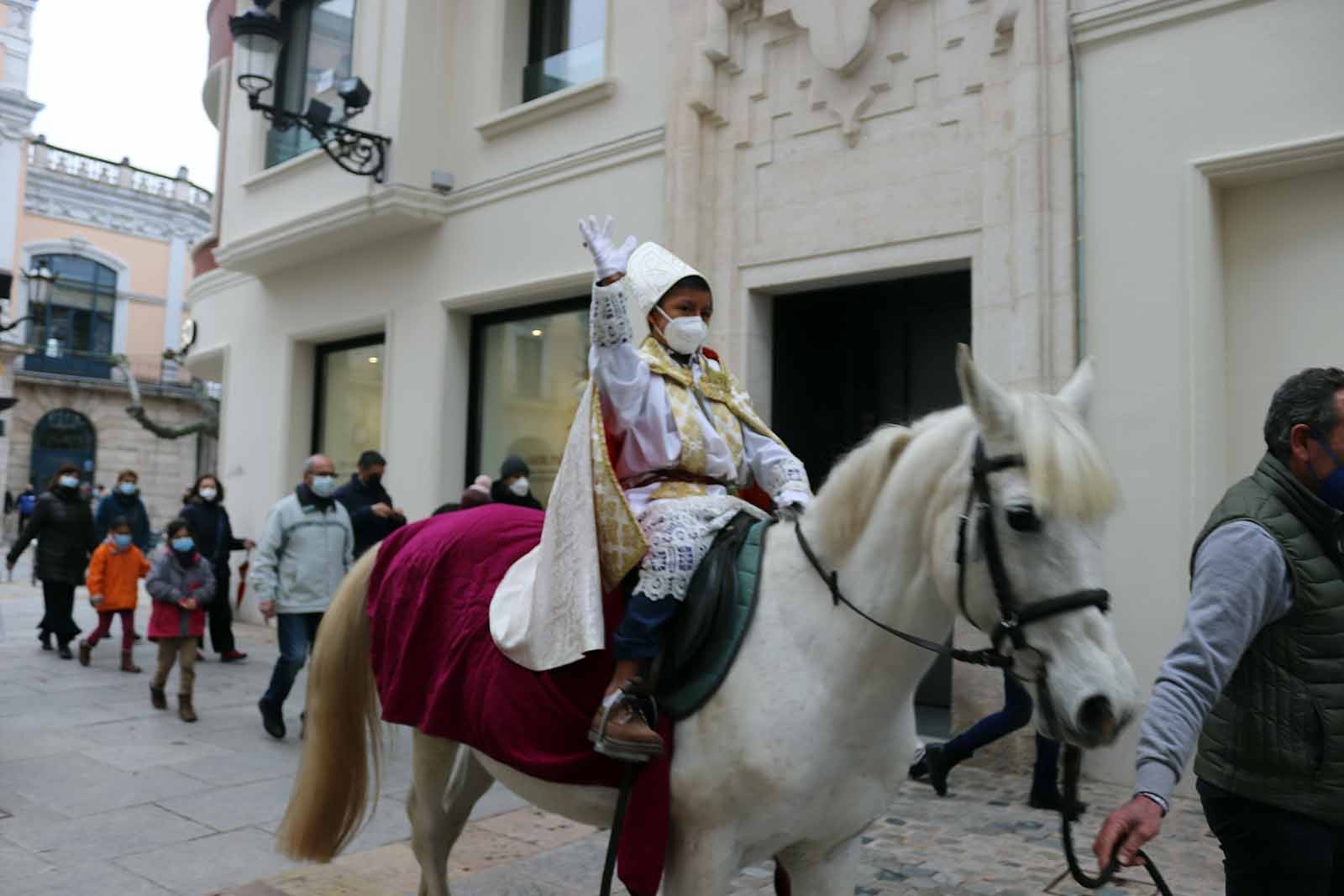 El obispillo saluda desde su caballo.