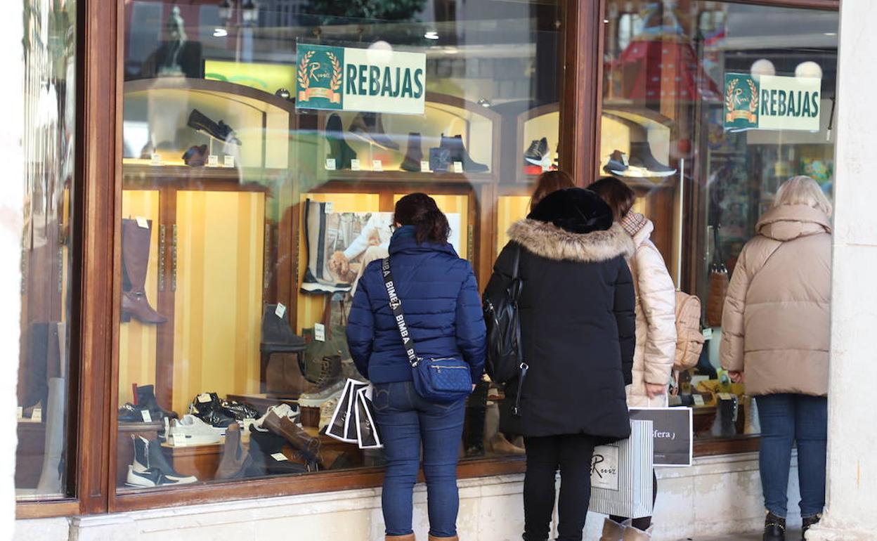Los burgaleses echan un vistazo a los escaparates en rebajas. 