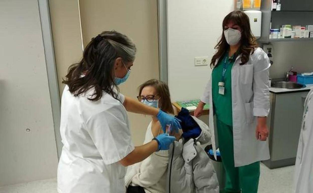 Personal de enfermería administran una vacuna en un centro de salud.