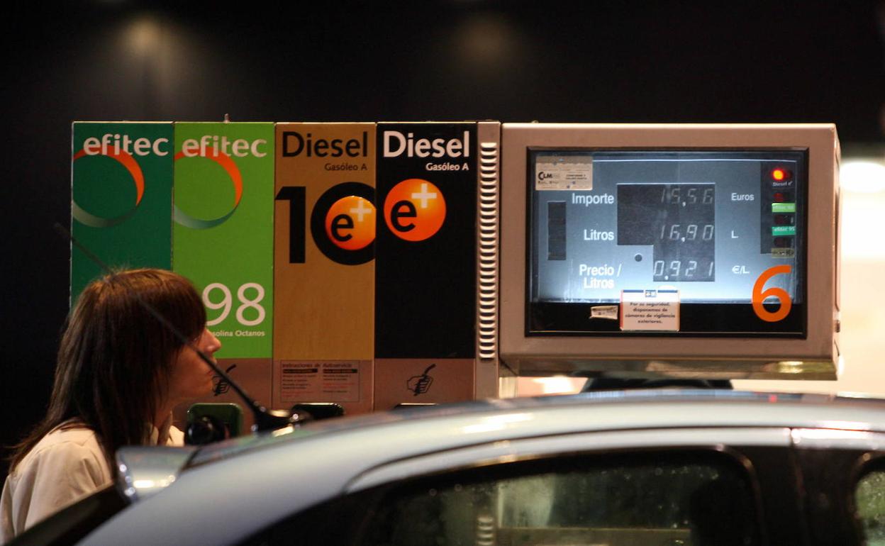 Mujer llena el depósito de su automóvil en una gasolinera de Madrid. 