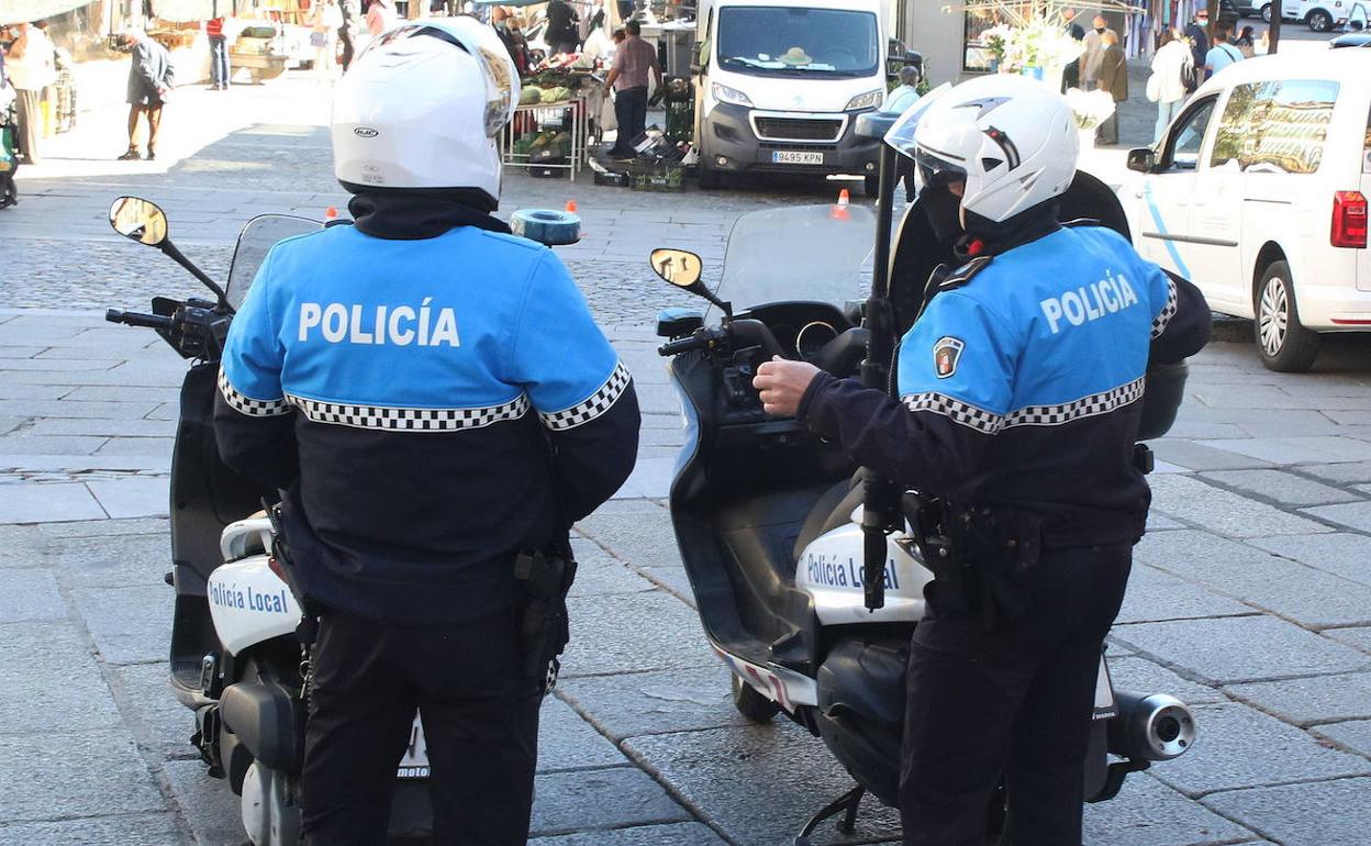 Una pareja de policías locales patrullan en moto por Segovia. 