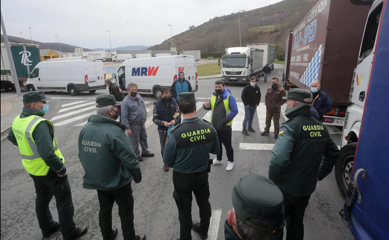 Agentes de la Guardia Civil junto a varios camioneros afectados por el paro.