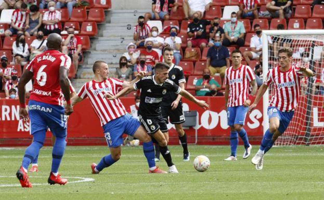 Raúl Navarro, rodeado de rivales del Sporting de Gijón en el partido de la primera vuelta.