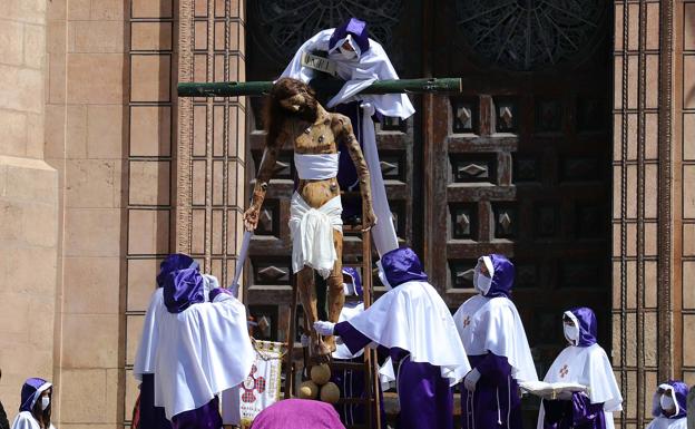 Los cofrades de Las Siete Palabras descienden al Santísimo Cristo de Burgos de la cruz tras quitarle los clavos