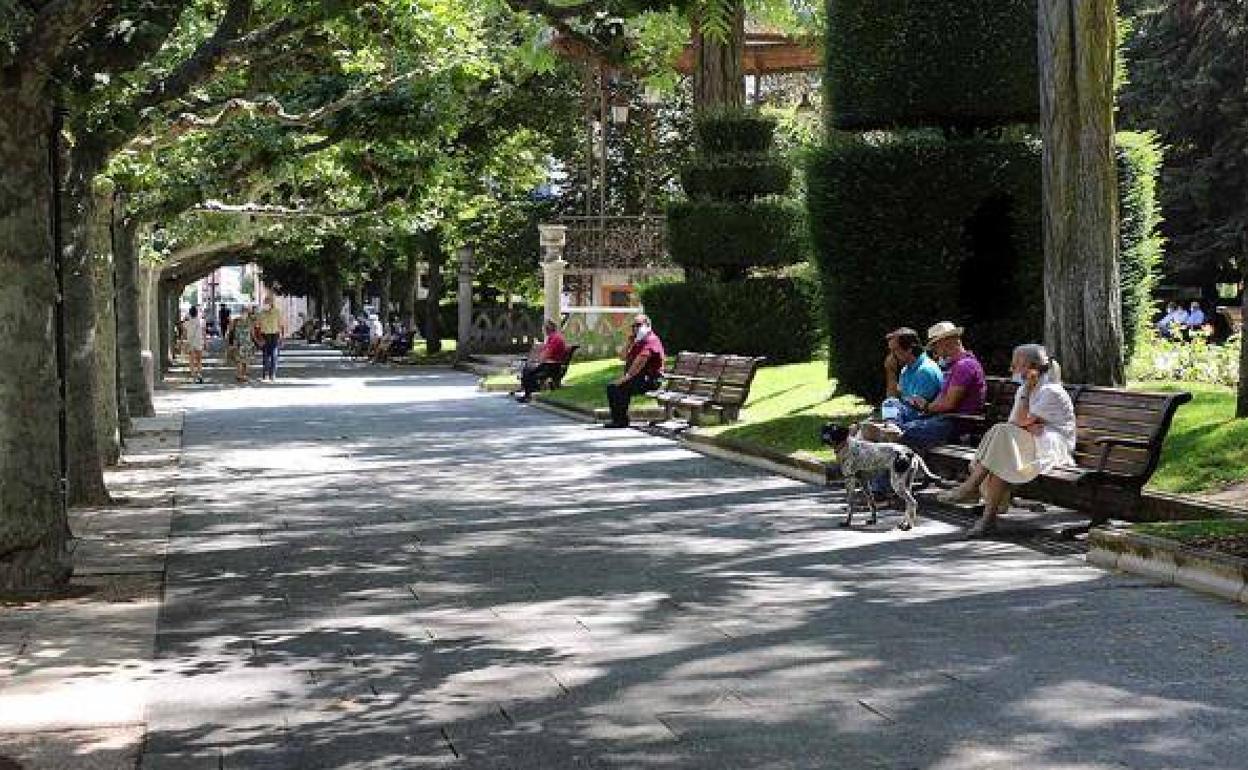 Burgaleses refugiándose a la sombra en el paseo del Espolón de Burgos.