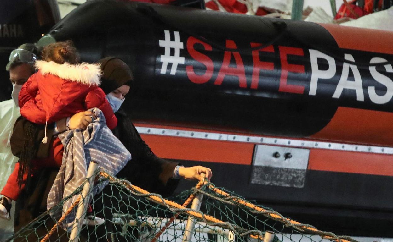 Refugiados bajan al puerto de Palermo (Italia) por la pasarela del barco que los rescató. 