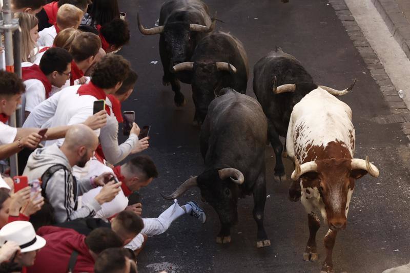 Los mozos corren ante los toros de la ganadería de José Escolar durante el tercer del encierro de San Fermín.