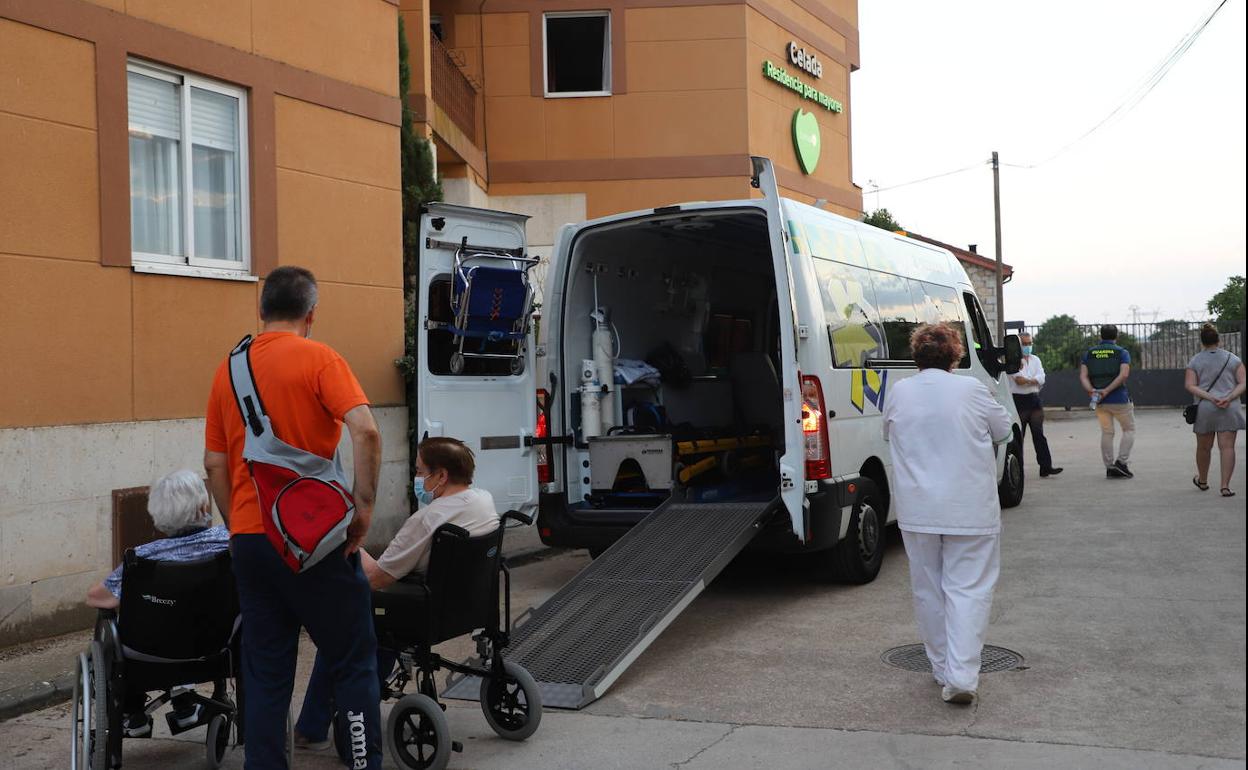 Cuidadores y familiares ayudan al traslado de los ancianos residentes en Celada del Camino tras el incendio
