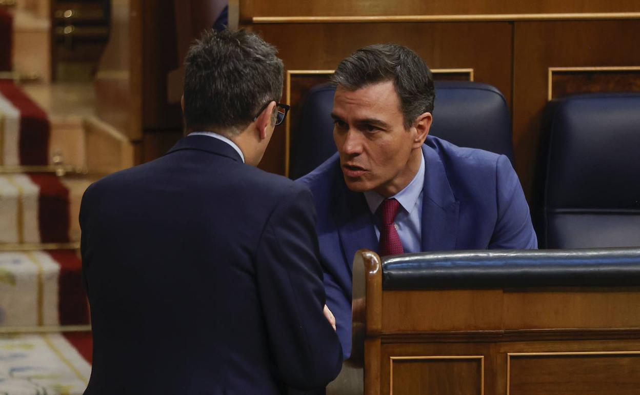 Pedro Sánchez y Félix Bolaños, charlan en el hemiciclo del Congreso de los Diputados.