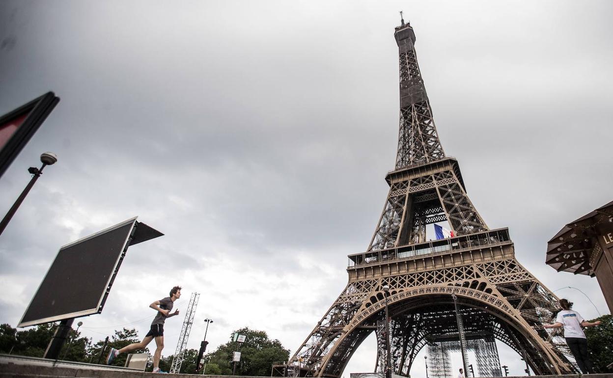 Un hombre corre junto a la torre Eiffel