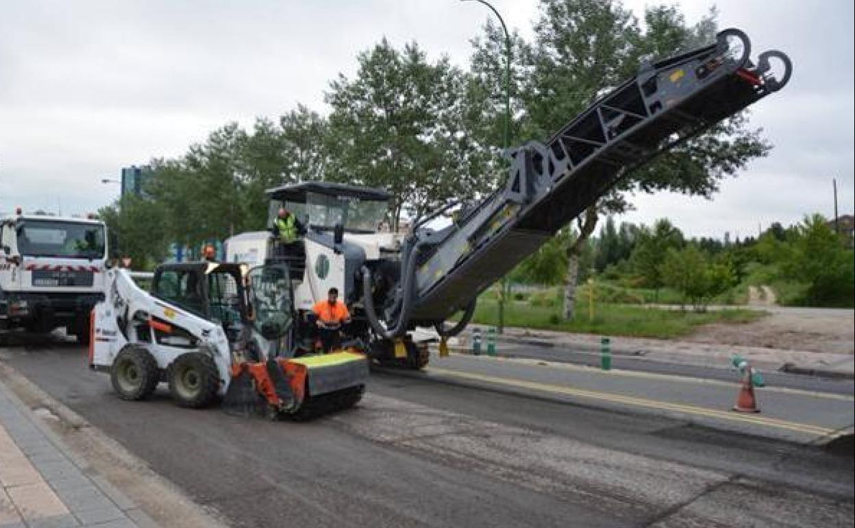 Operarios asfaltan una carretera de Burgos 