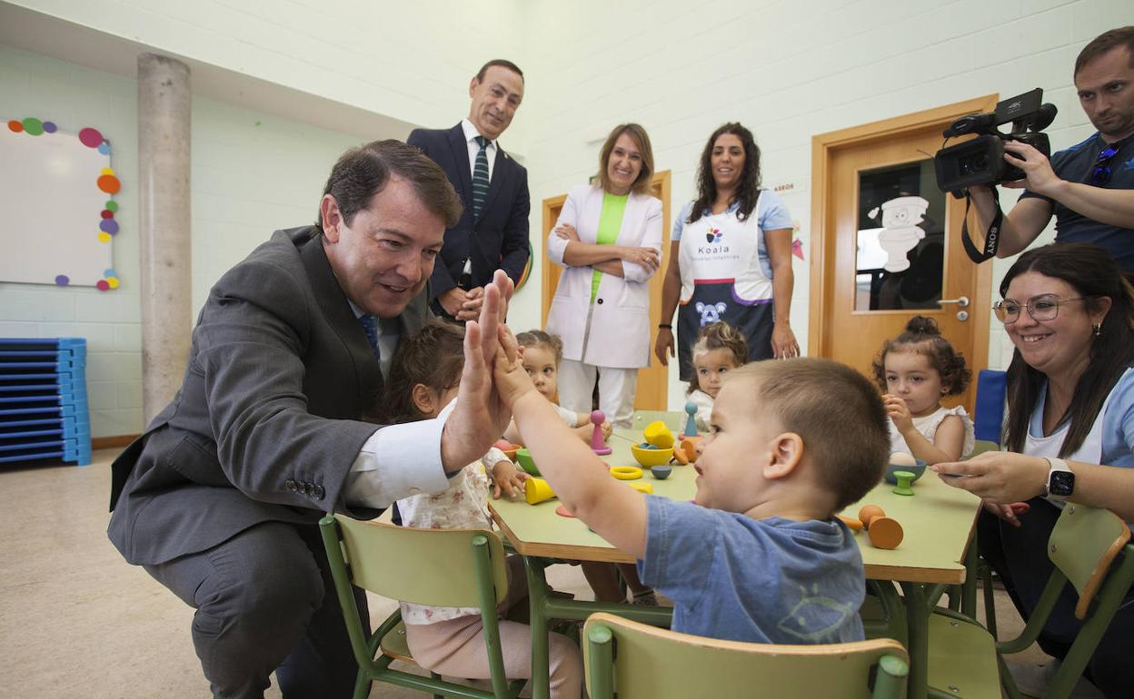 El presidente Alfonso Fernández Mañueco choca la mano con un niño en la Escuela Infantil de Carbajosa de la Sagrada en Salamanca