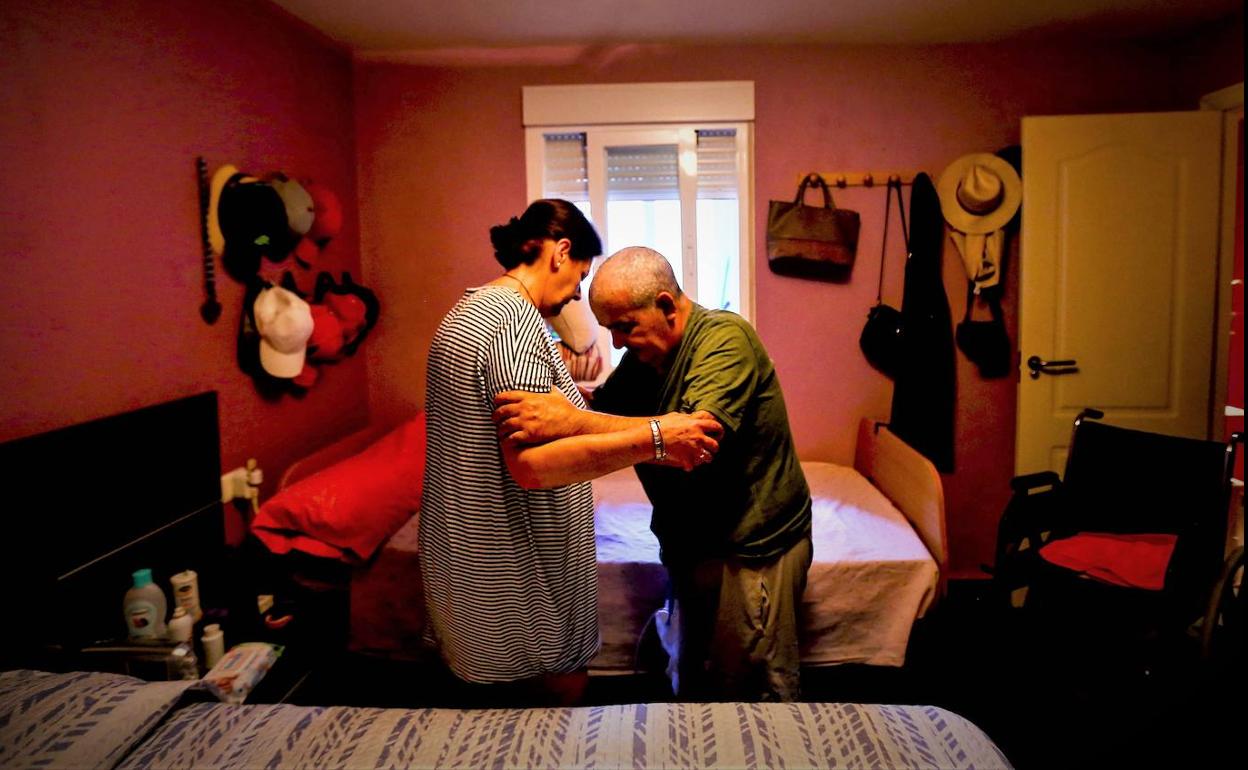 Foto en la que una trabajadora de ayuda a domicilio ayuda a una persona en su casa. 