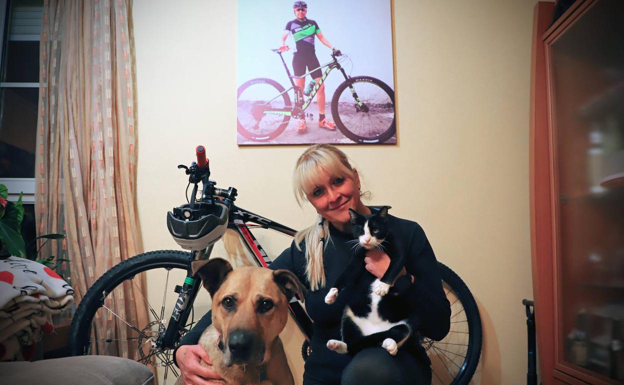 Susana con sus dos compañeras, Maya y Vega, bajo la fotografía de Marce y junto a su inseparable bicicleta. 