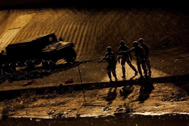 Miembros de la Guardia Nacional de Texas colocan alambradas en la ribera estadounidense del río Bravo.