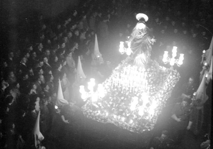 Imagen principal - Costaleros de La Soledad junto al paso titular, el Descendimiento iluminado y cofrades y miembros de la Iglesia en la procesión del Viernes Santo de 1957