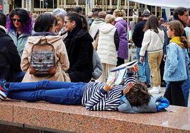 Un niño lee un libro en la plaza Mayor de Burgos donde se encontraba la feria por el Día del Libro.