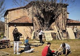 Los jóvenes encargados de la organización preparan los decorados del festival en la campa donde se celebrará.