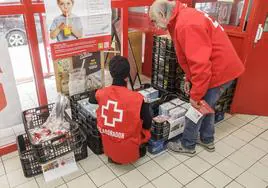 Miembros de Cruz Roja preparan lotes de alimentos para repartir entre los necesitados.