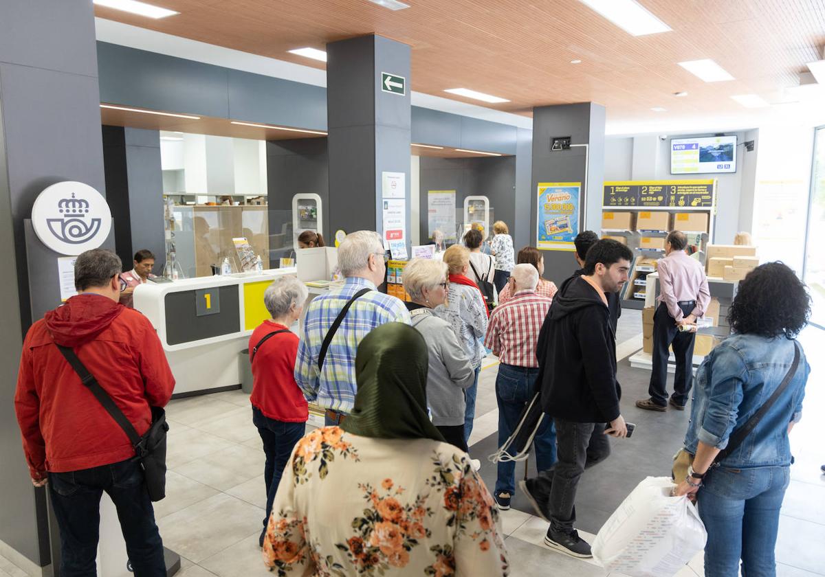 Colas en una oficina de Correos para solicitar el voto por correo.