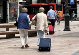 Burgaleses con maletas por el centro de la ciudad.