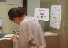 Una joven rellena la documentación para votar por correo.