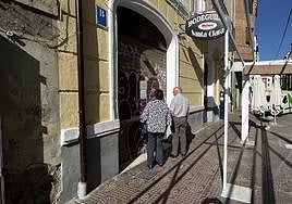 Dos personas leen la esquela de Carlos en la Bodeguilla Santa Clara.