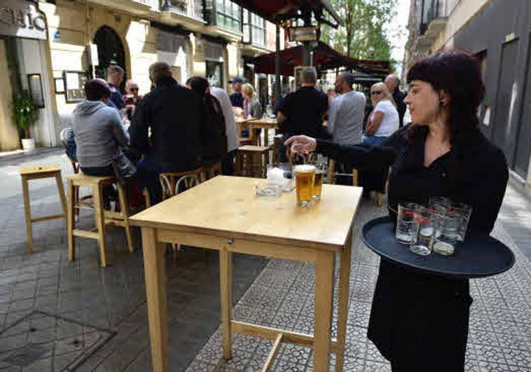 Una camarera recoge una mesa.