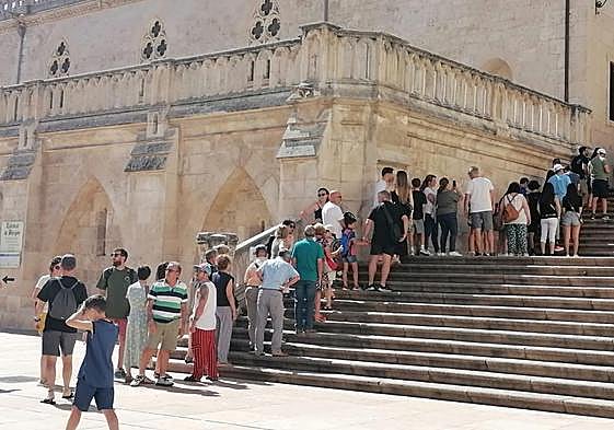 Turistas buscando la sombra en la escalinara de la Catedral.