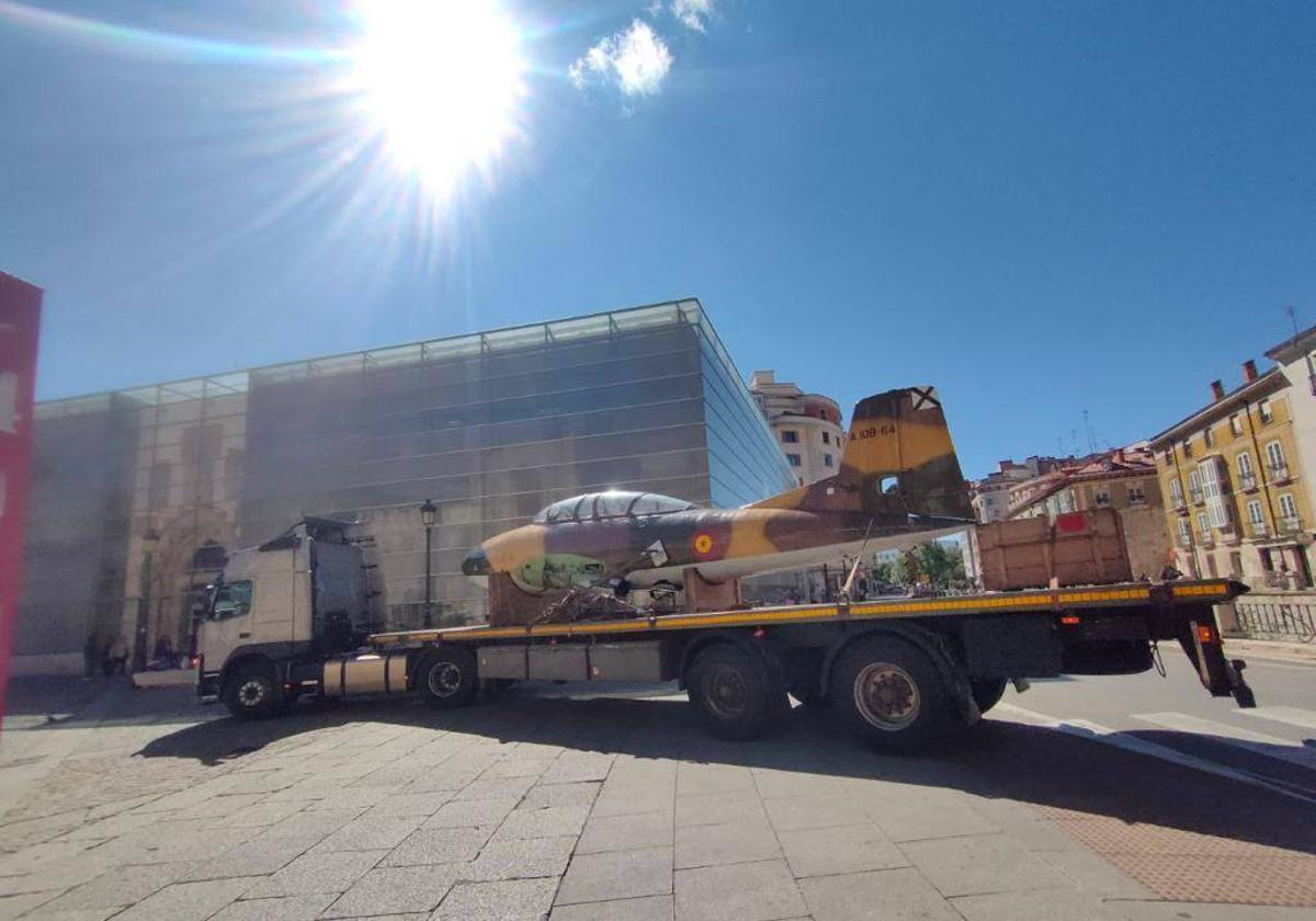 Un camión transporta un avión histórico real por el centro de Burgos.